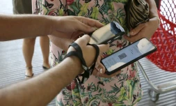 Une employée d'un centre commercial vérifie le pass sanitaire d'une cliente à Ajaccio, en Corse, le 16 août 2021