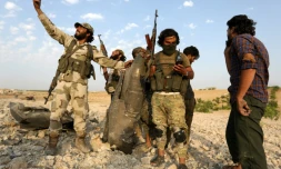 Des combattants rebelles montrent les débris d'un avion du régime syrien abattu, prÚs de Khan Cheikhoun, le 14 août 2019