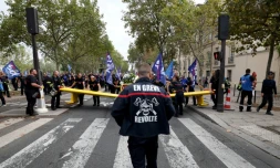 Un pompier portant une inscription "En grÚve" participe à une manifestation organisée par une large coalition de syndicats, à Paris, le 28 septembre 2026