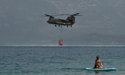 Un hélicoptère Ch-47D Chinook participant à la lutte contre les incendies en Grèce se ravitaille en eau le 1er août 2021 à Patras, à environ 200 kilomètres à l'ouest d'Athènes