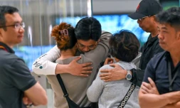 Les passagers du vol SQ321 de Singapore Airlines entre Londres et Singapour, qui a fait un atterrissage d'urgence à Bangkok, retrouvent les membres de leur famille à leur arrivée à l'aéroport de Changi de Singapour, le 22 mai 2024