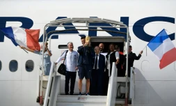 Le capitaine des Bleus Hugo Lloris brandit le trophée de champion du monde aux côtés de Didier Deschamps et Le Graët, le 16 juillet 2018 à l'Aéroport de Roissy