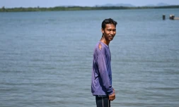 Pirun Kla-Talay, qui a perdu ses parents dans le tsunami de 2004, debout sur une jetée dans le district de Bang Wa, dans la province de Phang Nga, le 19 novembre 2024 en Thaïlande