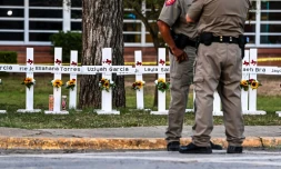 Des policiers se tiennent le 26 mai 2022 devant un mémorial de fortune pour les victimes de la fusillade dans l'école primaire Robb d'Uvalde au Texas