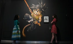 Des employĂ©s d'un musĂ©e posent Ă cotĂ© d'une Ćuvre d'art de la sĂ©rie de mangas Dragon Ball, de Toriyama Akira, lors d'une avant-premiĂšre pour l'exposition "Manga" au British Museum Ă Londres, le 22 mai 2019