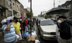 Le pasteur new-yorkais Fabian Arias (à droite) parle à des GuatémaltÚques venus profiter d'une distribution de nourriture qu'il organise pour les immigrés hispaniques, le 22 mai 2020 à Harlem