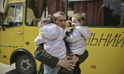 Dmytro Mosur, 32 ans, qui a perdu sa femme dans un bombardement près de Severodonetsk porte ses jumelles de deux ans, en attendant d'être évacués de Lyssytchank, le 20 mai 2022