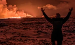 Un habitant regarde de la fumée sortir d'une fissure dans la péninsule de Reykjanes, au sud de la capitale Reykjavik, en Islande, le 18 décembre 2023