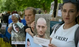 Des Ukrainiens brandissent des portraits de leurs parents captifs ou disparus dans l'espoir qu'ils seront reconnus par l'un ou l'autre des prisonniers de guerre libérés dans le cadre d'un échange avec la Russie, le 23 mai 2025 