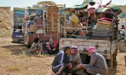 Des réfugiés syriens attendent le départ du convoi qui les ramènera chez eux, dans la localité d'Arsal, dans l'est du Liban, le 28 juin 2018