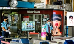 En Thaïlande, des forces de sécurité postées à un point de contrôle des températures, près d'un salon de manucure fermé, à une station du métro de Bankgok le 2 janvier 2021