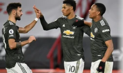 Les attaquants de Manchester United, l'Anglais Marcus Rashford (c) et le Français Anthony Martial, tous les deux buteurs, sont félicités par le milieu de terrain portugais Bruno Fernandes, lors de leur match de Premier League, le 17 décembre 2020 à Sheffield