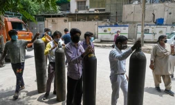 Des gens attendent pour remplir des bouteilles d'oxygĂšne Ă New Delhi le 12 mai 2021