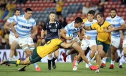 Les Australiens Reece Hodge (g) et Michael Cooper tentent de stopper l'Argentin Bautista Delguy, lors de leur match comptant pour la 4e journée du Rugby Championship, le 21 novembre 2020 à Newcastle en Australie (Nouvelle-Galles du sud)