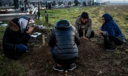 La famille Husseini autour de la tombe de Madina dans le cimetière de Sid, le 7 décembre 2017, en Serbie