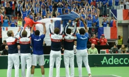 L'équipe de France de Coupe Davis agite un drapeau tricolore devant la tribune des supporters aprÚs la victoire 3-1 face aux TchÚques, le 17 juillet 2016 à Trinec