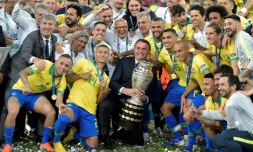 Le président du Brésil Jair Bolsonaro (c) pose avec les joueurs et le trophée aprÚs la victoire face au Pérou en finale de la Copa América, le 7 juillet 2019 à Rio de Janeiro