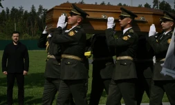 Le président ukrainien Volodymyr Zelensky (g) participe à la cérémonie de réinhumation du leader nationaliste controversé Andriï Melnyk, décédé en 1964 et ancien chef d'une branche de l'Organisation des nationalistes ukrainiens (OUN), ainsi que de son épouse Sofia, au cimetière national militaire commémoratif près de Kiev, le 25 mai 2026