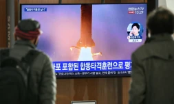 Des personnes regardent les images d'un tir de missiles par la Corée du nord, le 9 mars 2020 dans une gare de Séoul, en Corée du Sud