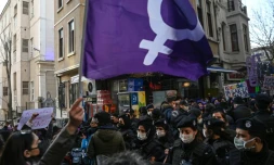 Un drapeau féministe brandi devant les forces de l'ordre lors d'une marche organisée à l'occasion de la journée mondiale des droits des femmes, à Istanbul, le 8 mars 2021