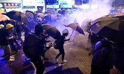 Des manifestants tentent de se protéger des nuages de gaz lacrymogène, le 28 juillet 2019 à Hong Kong