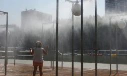 Une femme se rafraĂźchit sous un brumisateur le 24 juillet 2019 Ă Paris