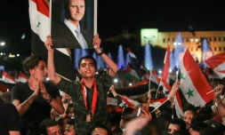 Des Syriens brandissent des drapeaux nationaux et le portrait de Bachar al-Assad le 27 mai 2021 à Damas, au lendemain de l'élection présidentielle pour laquelle il est donné vainqueur