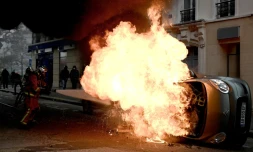 Un pompier tente d'éteindre le feu qui détruit une voiture place d'Italie à Paris, le 16 novembre 2019, en marge d'une manifestation des "gilets jaunes" 