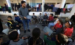 Tareq al-Ennabi, un Palestinien de 25 ans, donne un cours d'anglais à des enfants déplacés dans une école devenue camp de déplacés à Rafah, dans le sud de la bande de Gaza, le 29 novembre 2023