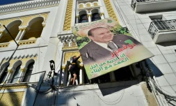 Des manifestants décrochent un portrait géant du président Bouteflika, le 22 février 2019 à Alger
