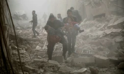 Des Syriens évacuent les victimes d'une attaque aérienne sur Douma, à l'est de Damas le 13 décembre 2015