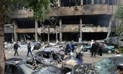 Des gens inspectent les dégâts causés à un bâtiment, ciblé par une frappe aérienne israélienne la veille, rue Mar Elias à Beyrouth, le 18 novembre 2024