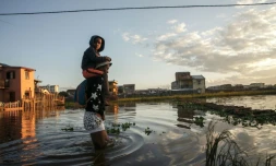 Des habitants marchent le 28 janvier 2022 dans le quartier inondé d'Ankasina à Antananarivo, capitale de Madagascar, après le passage de la tempête tropicale Ana