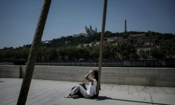 Une personne est assise sur les quais de la Saône, à Lyon, le 26 mai 2026, alors qu'une vague de chaleur frappe la France