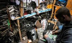 Un membre de l'ONG locale Electronic Waste Initiative Kenya (E-WIK) répare une carte-mère dans un atelier à Nairobi, au Kenya, le 3 décembre 2021

