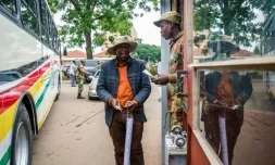 Un soldat contrôle des délégués à leur arrivée à une réunion cruciale du parti au pouvoir dimanche à Harare alors que le président Mugabe est lâché par ses principaux soutiens