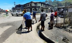 Des habitants nettoyent les rues après des émeutes meurtrières, le 28 novembre 2021 à Honiara, aux Iles Salomon