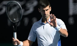 Novak Djokovic réagit lors d'un match contre l'Italien Jannik Sinner, le 26 janvier 2024 à Melbourne en Australie