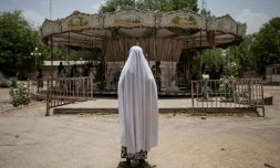 Une enfant regarde un manège d'un vieux parc d'attractions à l'abandon, le 27 avril 2017 à Maiduguri, au Nigeria