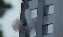 Une main tenant un tissu apparaît à la fenêtre d'un appartement d'une tour d'habitation ravagée par un incendie, le 14 juin 2017 à Londres