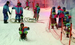 Des jeunes Saoudiens glissent sur des pentes enneigées installées dans un parc à neige à Ryad, le 20 juillet 2016