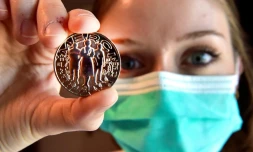 Un membre du personnel soignant montre la médaille créée par la Monnaie de Paris, en hommage aux corps médical, éboueurs, caissiers, agriculteurs etc., le 15 mai 2020 à Pessac, en Gironde