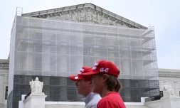 Deux hommes portant des casquettes "Make America Great Again" (MAGA, Rendre sa grandeur à l'Amérique), passent devant la Cour suprême des Etats-Unis, à Washington, le 27 juin 2025