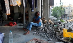 Une fille palestinienne déplacée est assise dans un bùtiment endommagé utilisé comme abri temporaire dans le camp de réfugiés d'al-Bureij dans le centre de la bande de Gaza, le 12 juin 2024