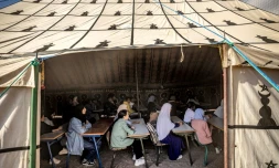 Des élÚves suivent des cours sous une tente dans une école de fortune dans le village d'Asni, touché par le tremblement de terre, dans la province d'Al-Haouz, au Maroc, le 18 septembre 2023