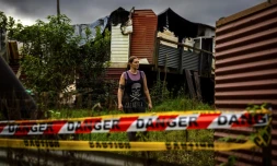 L'Australienne Rahima Jackson, le 15 mai 2022 à Lismore, en Nouvelles Galles du Sud, devant sa maison détruite par les inondations catastrophiques qui ont touché la région trois mois plus tôt
