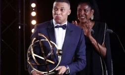 Kylian Mbappé avec le trophée UNFP de meilleur joueur de la saison de Ligue 1 que vient de lui remettre Marie-Josée Pérec, derriÚre lui, le 13 mai 2024 à Paris