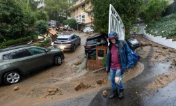 Scoot Toro se tient près des maisons de ses voisins endommagés par un glissement de terrain et une inondation éclair à Los Angeles, en Californie, le 5 février 2024