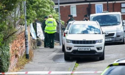 Des policiers sur les lieux d'une agression au couteau avenue Kinnaird, dans le nord de Belfast, en Irlande du Nord, le 9 juin 2026