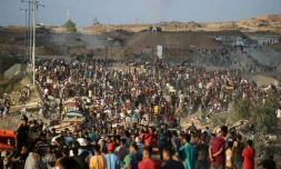 Des Palestiniens rassemblés à un point de distribution d'aide mis en place par la Fondation humanitaire de Gaza (GHF), près du camp de réfugiés de Nousseirat, dans le centre de la bande de Gaza, le 25 juin 2025